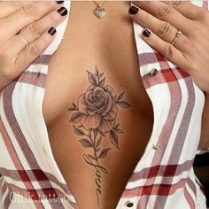 a woman with a flower tattoo on her back is looking down at the camera while holding her hands up to her chest