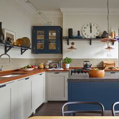 a kitchen filled with lots of counter top space next to a clock on the wall