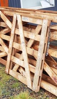 a large wooden crate sitting on top of a grass covered field