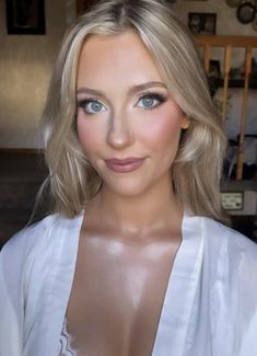 a woman with blonde hair and blue eyes wearing a white shirt is posing for the camera