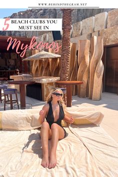 a woman sitting on top of a towel next to a table