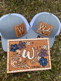 two hats are laying on the grass next to a sign that says w and u