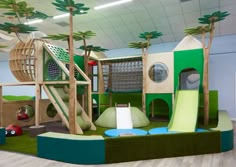 children's play area with slide, climbing wall and palm trees on the walls