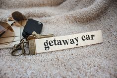 there is a keychain that says getaway car next to sunglasses on the ground