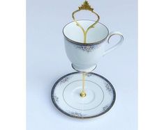 a tea cup with a saucer on it and a gold crown in the middle