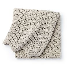 a crocheted blanket is folded on top of a white surface