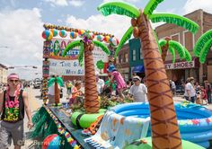 a man standing next to an inflatable float with palm trees on the side