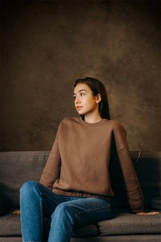 a young woman sitting on top of a couch