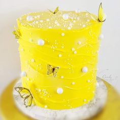 there is a yellow cake with butterflies on it