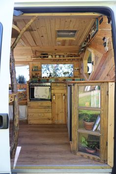 the inside of a van with wood paneling and wooden flooring on the outside