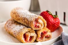 two pastries on a plate with strawberries