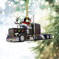 a black truck ornament hanging from a christmas tree