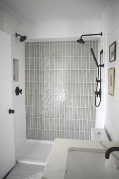 a bathroom with white tile and black fixtures