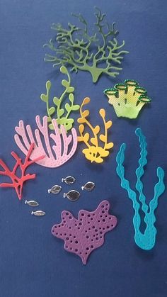 various sea animals and corals on a blue tablecloth with other items to make it look like they are made out of plastic