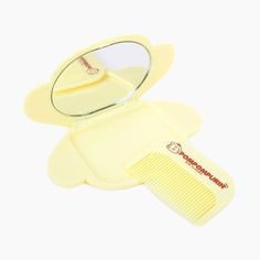 a yellow comb and mirror sitting on top of a table