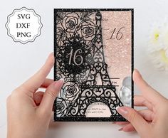 two hands holding up a card with the eiffel tower in black and pink