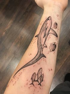 a shark tattoo on the arm with other fish and sea creatures around it's neck