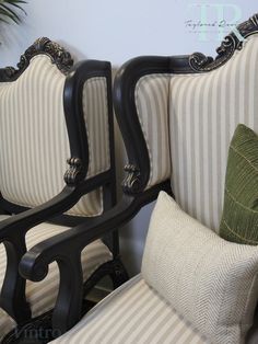 two black and white striped chairs next to each other in front of a potted plant