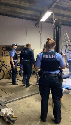 two police officers standing in a garage with their bikes on the other side of the room