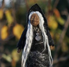 a black doll with white hair and a necklace