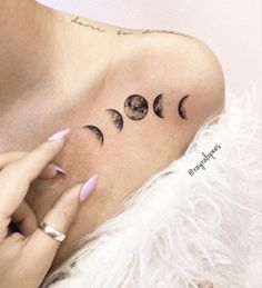 a woman with three phases of the moon tattoo on her shoulder