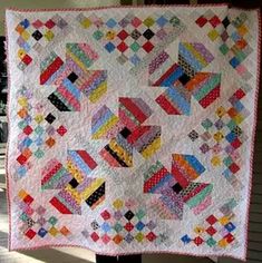 a colorful quilt is hanging on the wall