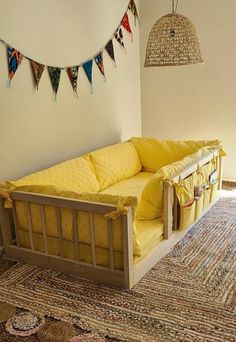 a yellow couch sitting on top of a rug in a living room