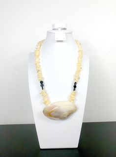 Mother of pearl/Abalone shell and onyx bead statement necklace from the 1970s. This is a truly stunning Mid-Century piece and has all of the flourishes to designate it a true runway quality necklace. One strand of Mother of Pearl nugget beads and onyx spacer beads connect to a large, stately natural clam shell. This piece is more than likely Korean or Japanese based on the materials and quality. Overall, this necklace measures 28 inches long while the clam shell is 4 x 2 inches. The closure is made from durable silver hook closure. Absolutely a statement piece befitting of any collector or for the lucky individual to receive this as a gift!  Given that this piece is pre-loved, any wear that is associated is simply due to the fact that it's vintage. All items offered by our shop are sold as Italian Necklace, Tropical Gifts, Beaded Statement Necklace, Clam Shell, Onyx Bead, Necklace Statement, Themed Jewelry, Shell Pendant, Abalone Shell