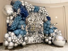 a large number made out of silver and blue balloons in the middle of a room