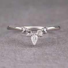 a white gold ring with three pear shaped diamonds on the side and two smaller pears at the top