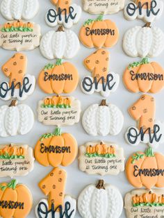 decorated cookies with names and pumpkins are arranged on a white tablecloth that says one, one, one, one