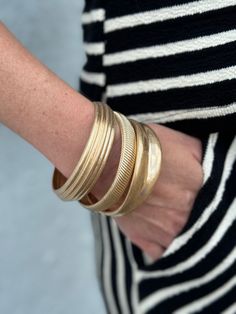 This set of 3 textured cast bangle bracelets in faux gold adds a touch of elegance to any outfit. The unique texture adds dimension and the faux gold gives off a luxurious vibe. Perfect for layering or wearing alone, these bracelets are a must-have for any fashion enthusiast. Chic Gold Stackable Bangle, Bohemian Handmade Gold Bangle, Gold Bohemian Bangle Cuff Bracelet, Chic Gold Stackable Cuff Bracelet, Elegant Stackable Brass Bangle, Luxury Brass Bangle Bracelet, Gold-toned Brass Bangle Bracelet, Modern Gold-toned Brass Bangle Bracelet, Bangle Bracelet Set