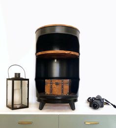 a wooden chest sitting on top of a white table next to a lamp and lantern