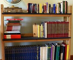 a book shelf filled with lots of books next to a clock on top of a wall