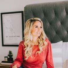 a woman sitting on top of a bed in a bedroom