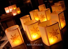 many lit candles sitting on top of a table next to each other with the words art of leis written on them