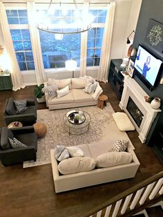 a living room filled with furniture and a flat screen tv mounted on a wall above a fire place