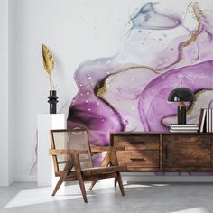 a room with a large painting on the wall and a chair in front of it