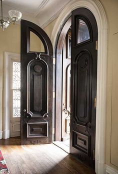 an entryway with two doors and a rug on the floor