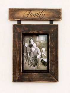 an old family photo hanging on a wall with the word family written in cursive font