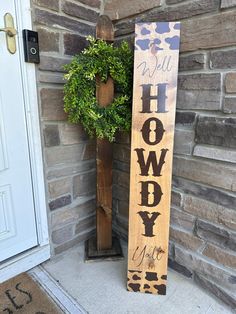 a wooden sign sitting next to a potted plant in front of a brick building