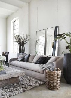 a living room filled with lots of furniture and plants