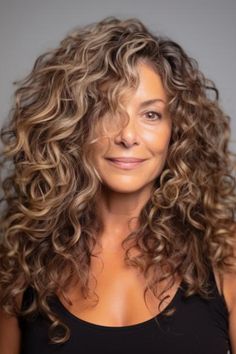 Rock your natural curls with a high-volume curly hairdo enhanced by a layered cut. This style gives the hair some body and depth, which is ideal for women with curly or coarse hair. Click here to check out more best long hairstyles for women over 60. Haircut For Wavy Hair Naturally Curly Long Layered, Blending Gray Hair Brunettes Short Curly, Long Curly Hair For Women Over 50, Haircuts For Long Curly Hair For Women, Curly Hairstyles For Women Over 40, Curly Hair Over 60 Women, Medium Length Curly Hairstyles Over 40, Razor Cut Shag Haircut