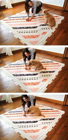 a woman in striped shirt petting a cat on top of a quilted rug