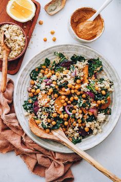 a white plate topped with chickpeas, spinach and quinoa salad