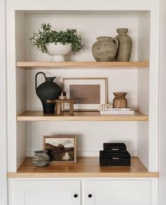 some shelves with vases and pictures on them