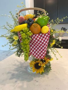 a basket filled with fruit and vegetables on top of a kitchen counter covered in sunflowers