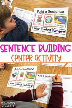 two children sitting at a table with their hands on the paper and writing sentence building center activity