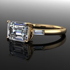 an emerald cut diamond ring with two baguets