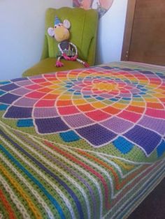 a crocheted bed with a colorful blanket on it